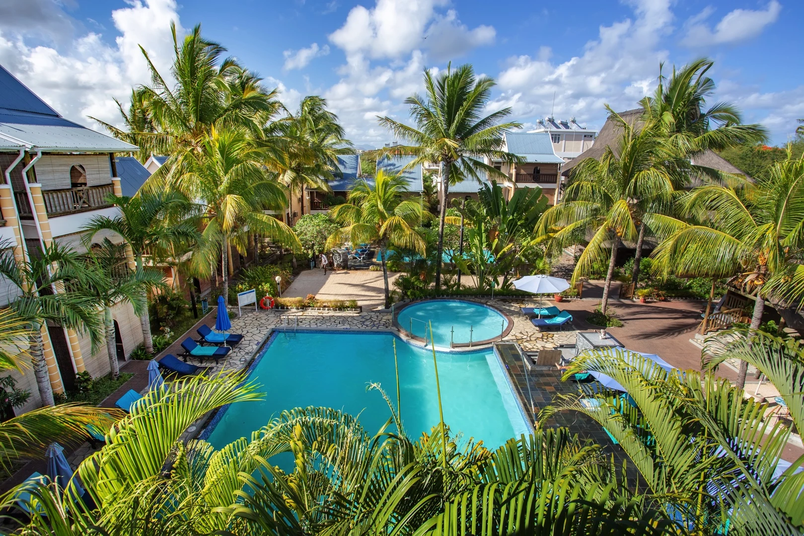 Le Palmiste Resort & Spa swimming pool surrounded by palm trees in Trou aux Biches Mauritius