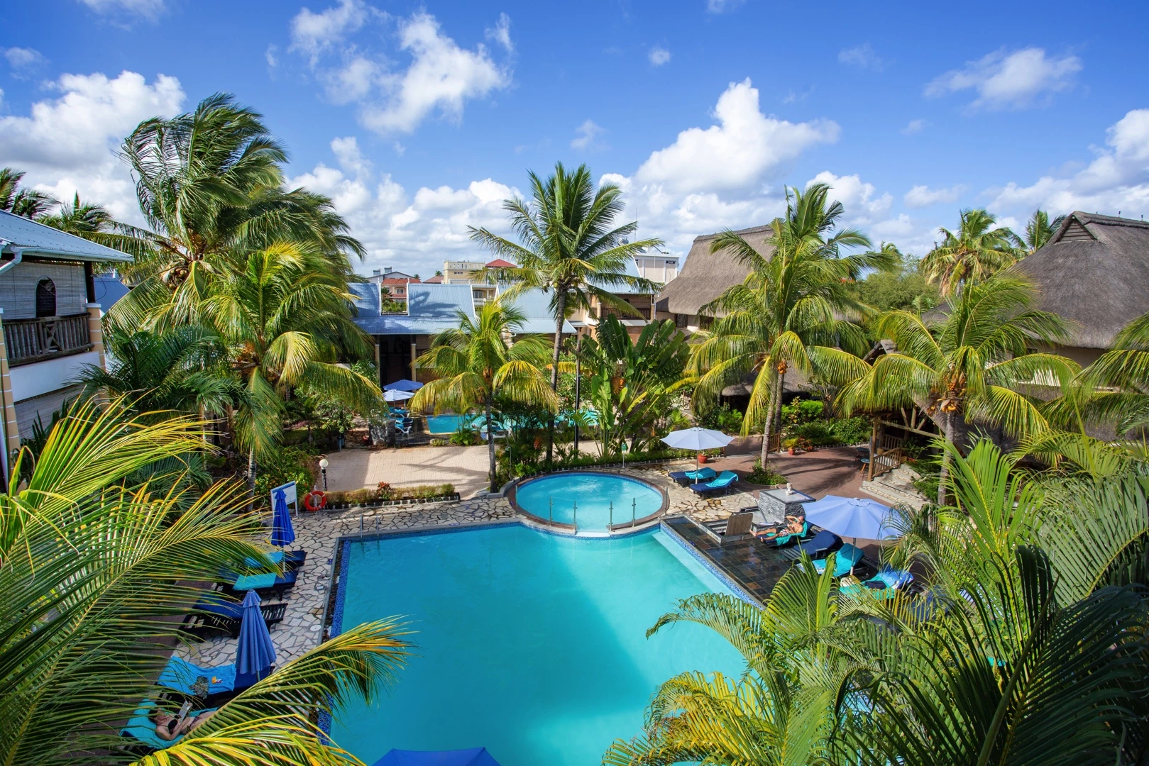 Le Palmiste Resort & Spa swimming pools set in a lush tropical garden.