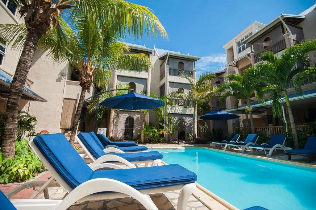 Outdoor swimming pool at Residence Le Palmiste Trou aux Biches with sun loungers